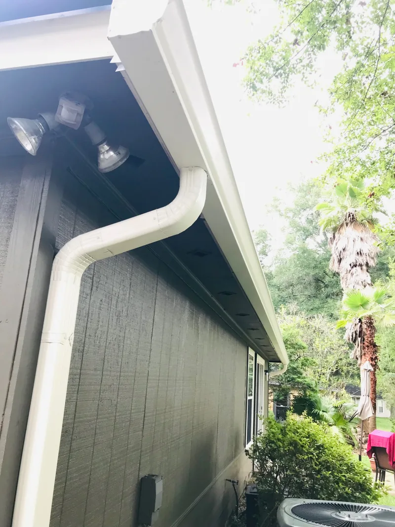 Finished seamless gutter corner and downspout on a local home